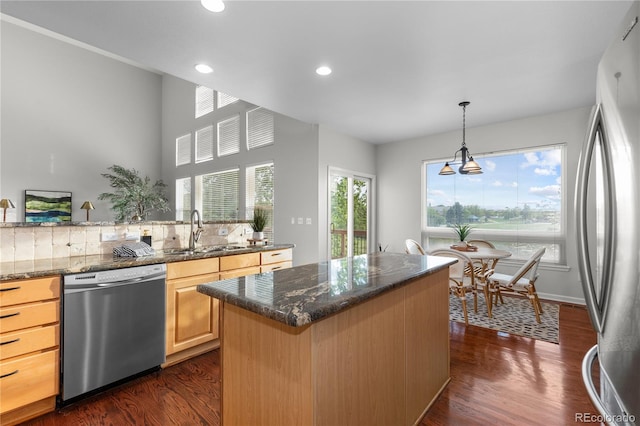 9453 Lark Sparrow Dr, Highlands Ranch, CO 80126 - kitchen with appliances with stainless steel finishes, a sink, light brown cabinets, dark wood-type flooring, and a kitchen island