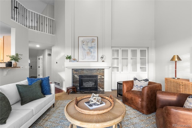 9453 Lark Sparrow Dr, Highlands Ranch, CO 80126 - living room featuring a towering ceiling, a stone fireplace, and baseboards