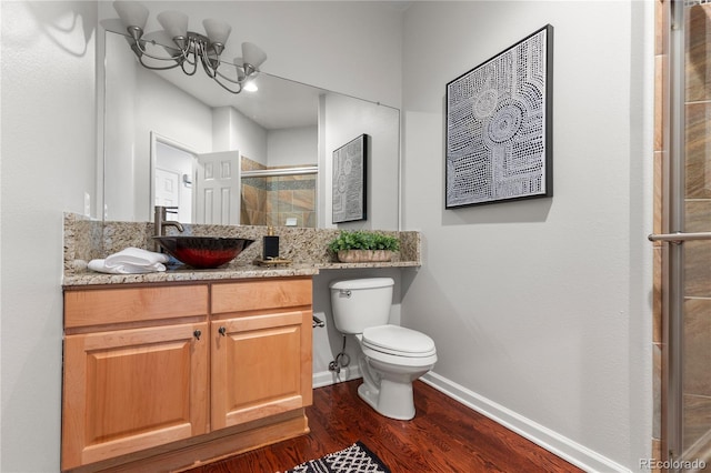 9453 Lark Sparrow Dr, Highlands Ranch, CO 80126 - bathroom with wood finished floors, a shower stall, toilet, vanity, and baseboards
