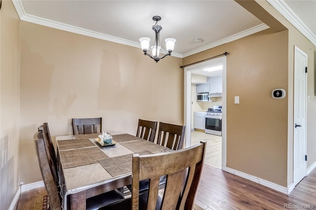 1881 E 95th Ave, Thornton, CO 80229 - dining space featuring an inviting chandelier, ornamental molding, baseboards, and light wood-type flooring