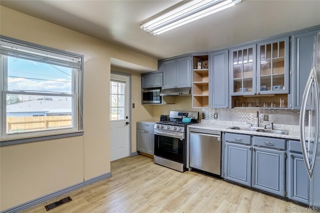 1881 E 95th Ave, Thornton, CO 80229 - kitchen with under cabinet range hood, stainless steel appliances, light wood-style floors, and light countertops