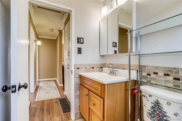 1881 E 95th Ave, Thornton, CO 80229 - bathroom featuring crown molding, tile walls, wood finished floors, and visible vents