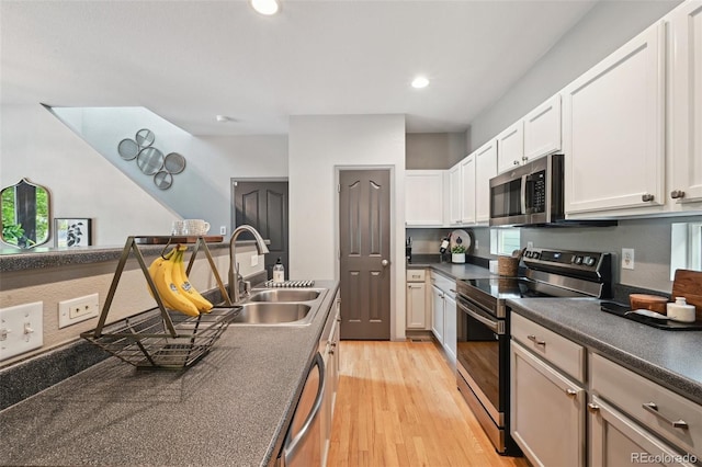2813 Central Park Blvd, Denver, CO 80238 - kitchen with stainless steel appliances, a sink, dark countertops, light wood-style floors, and healthy amount of natural light