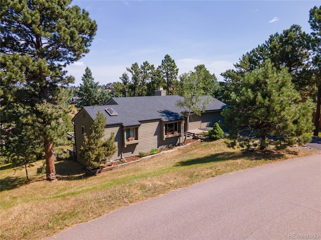 ranch-style house featuring a front lawn and a chimney