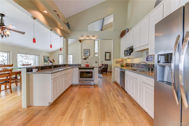 kitchen featuring light wood-style floors, white cabinetry, appliances with stainless steel finishes, and a sink