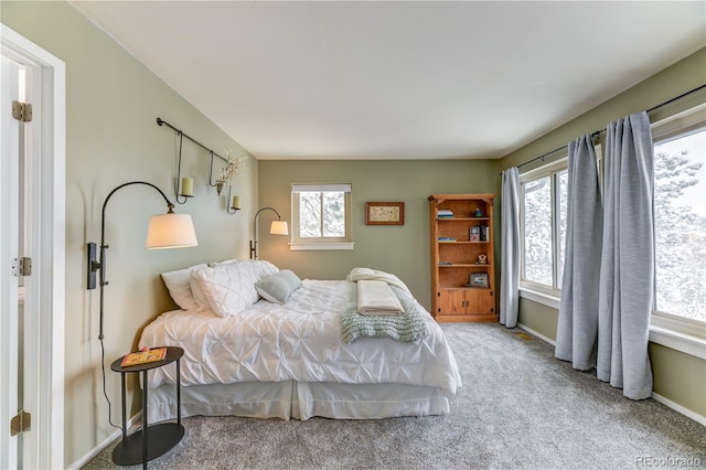 bedroom with carpet floors, multiple windows, and baseboards