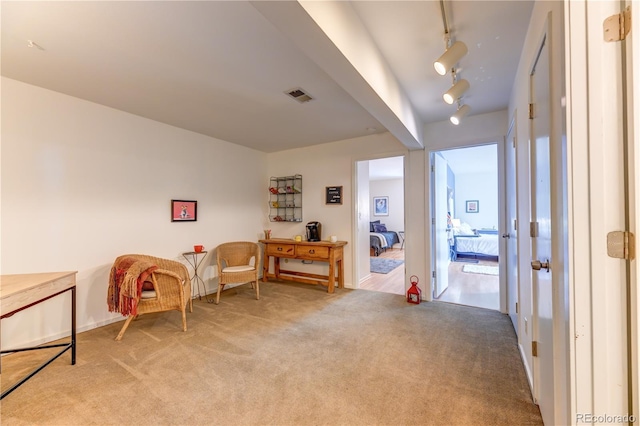 sitting room with light colored carpet, visible vents, and track lighting