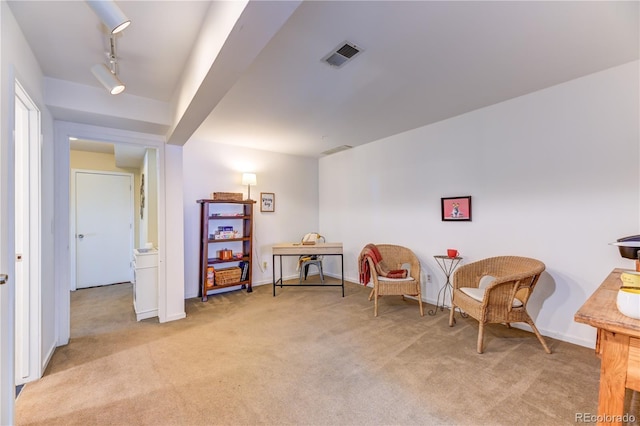 sitting room with light colored carpet, baseboards, visible vents, and track lighting