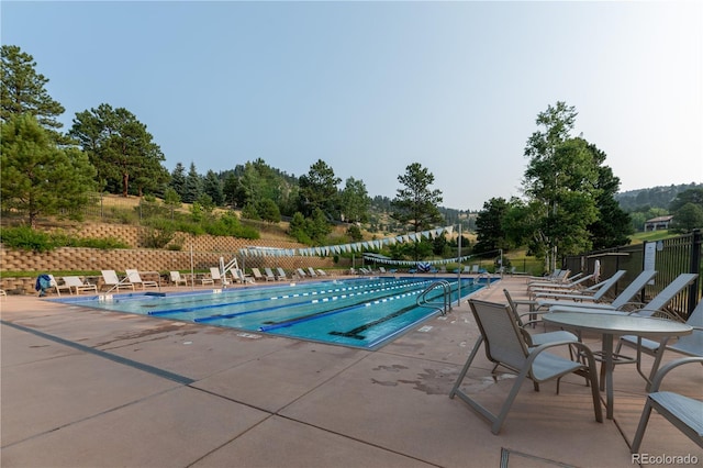 community pool featuring fence and a patio