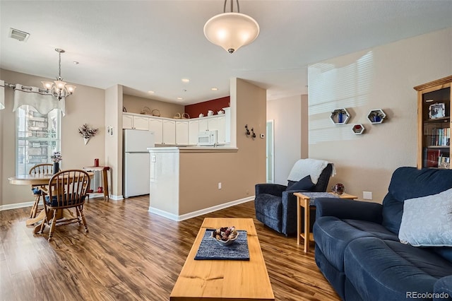 living room featuring dark wood finished floors, visible vents, a chandelier, and baseboards