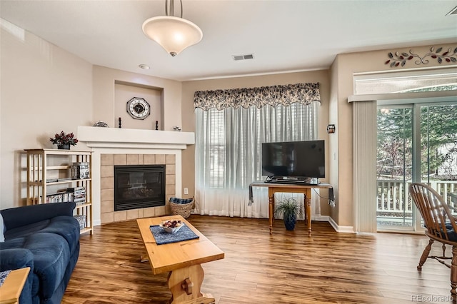 living area featuring visible vents, plenty of natural light, and wood finished floors