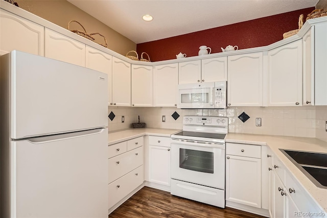 kitchen with decorative backsplash, white appliances, white cabinets, and dark wood-style floors