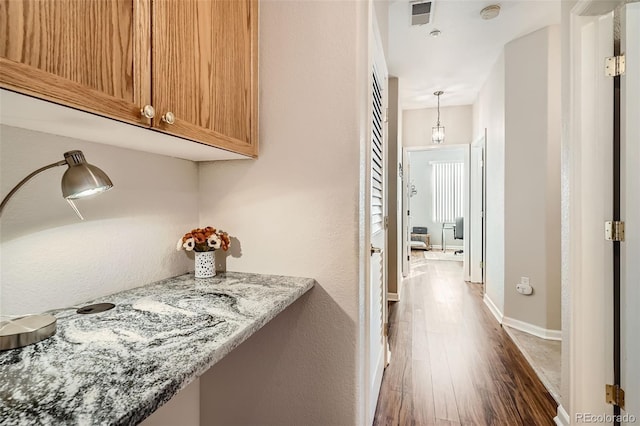 hall with dark wood-style floors and baseboards