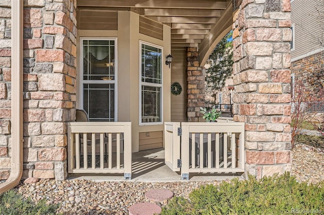 property entrance featuring brick siding, stone siding, and a porch