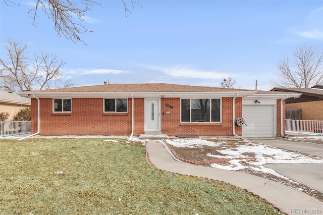 single story home with concrete driveway, brick siding, an attached garage, and a front yard