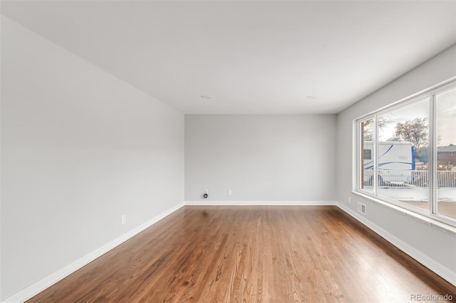 unfurnished room featuring baseboards and wood finished floors