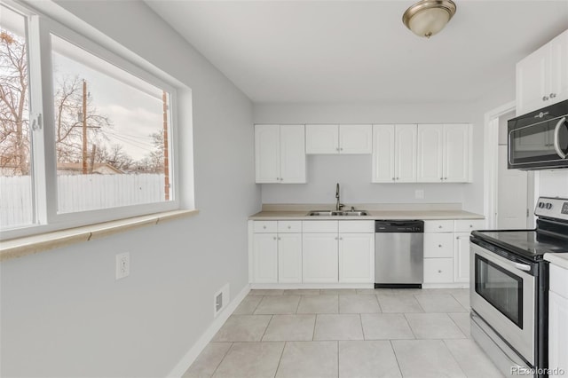 kitchen featuring white cabinets, a sink, stainless steel appliances, and light countertops