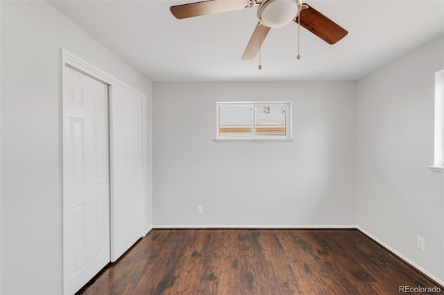 unfurnished bedroom featuring baseboards, a closet, a ceiling fan, and dark wood-type flooring