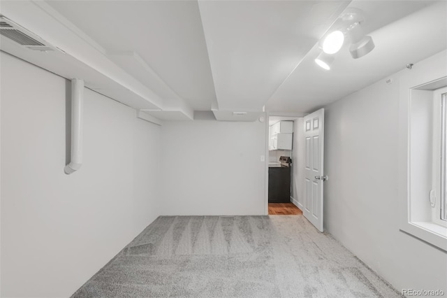 finished basement with visible vents and light colored carpet