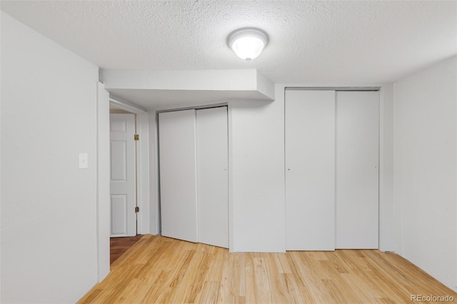 interior space with a textured ceiling and wood finished floors