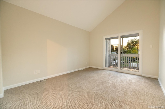 carpeted empty room with high vaulted ceiling