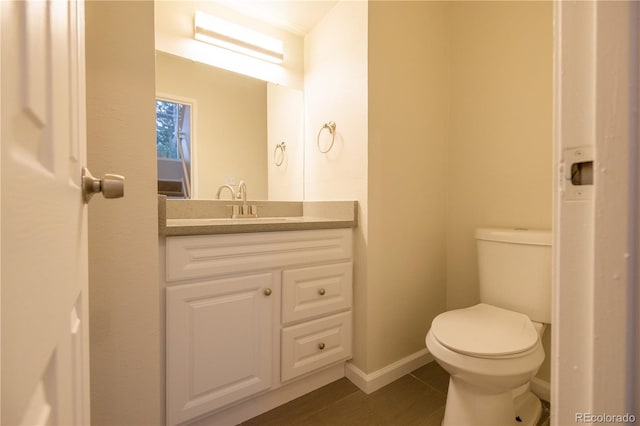 bathroom with vanity, toilet, and hardwood / wood-style flooring