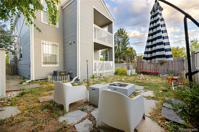 view of side of property featuring a balcony and a fire pit