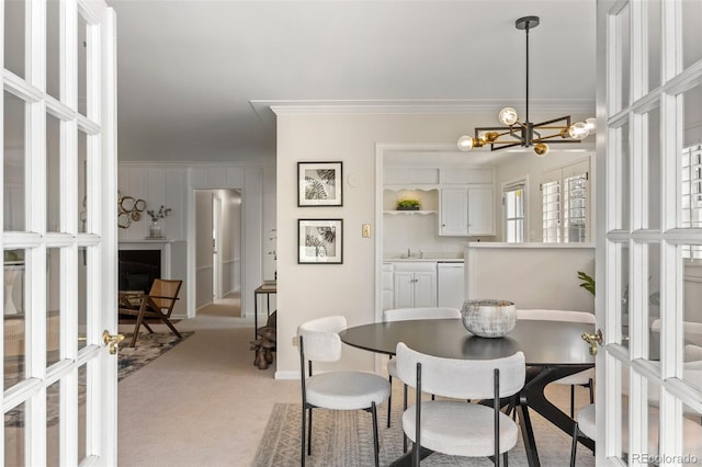 dining room with crown molding, a chandelier, and light carpet