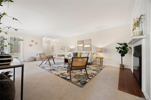 carpeted living room featuring baseboards and ornamental molding