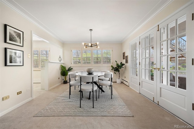 carpeted dining room featuring crown molding, a chandelier, baseboards, and a baseboard radiator