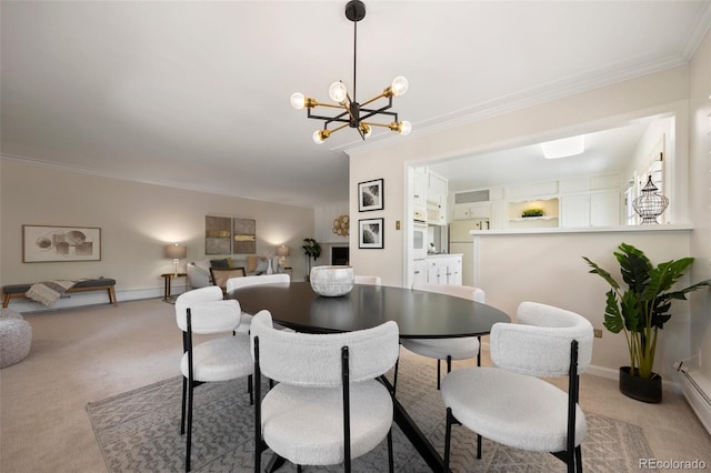 dining space featuring light colored carpet, crown molding, baseboards, and an inviting chandelier