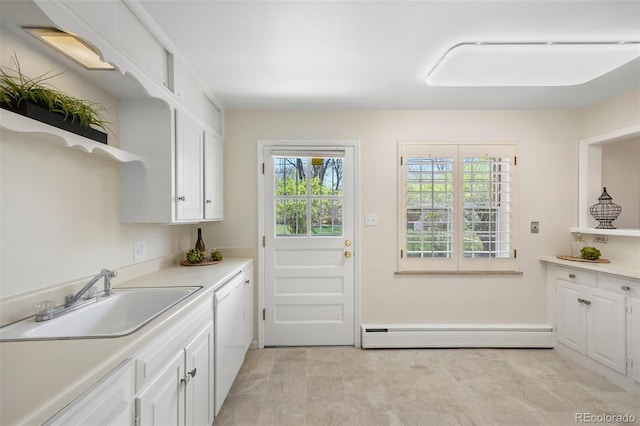 interior space featuring a sink, washing machine and clothes dryer, cabinet space, and baseboard heating