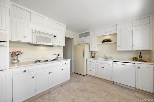 kitchen featuring light countertops, white cabinetry, a sink, and white appliances