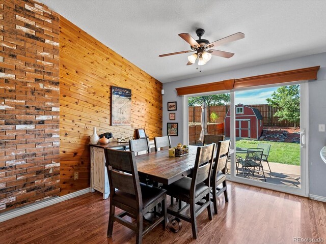 11877 W Bowles Cir, Littleton, CO 80127 - dining room featuring wooden walls, healthy amount of natural light, ceiling fan, and wood finished floors
