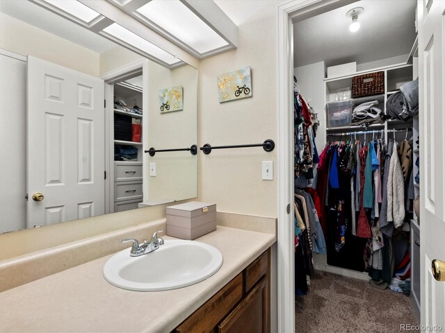 11877 W Bowles Cir, Littleton, CO 80127 - bathroom featuring vanity and a walk in closet