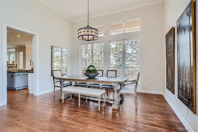 dining space with dark wood-type flooring, a chandelier, and crown molding