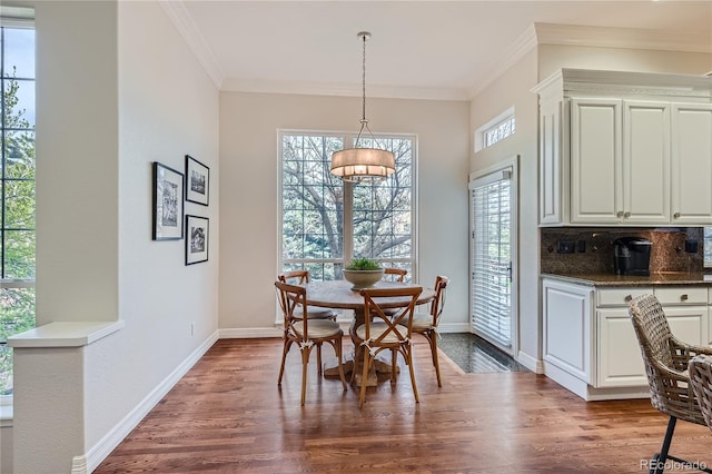 dining room featuring plenty of natural light, crown molding, and wood-type flooring