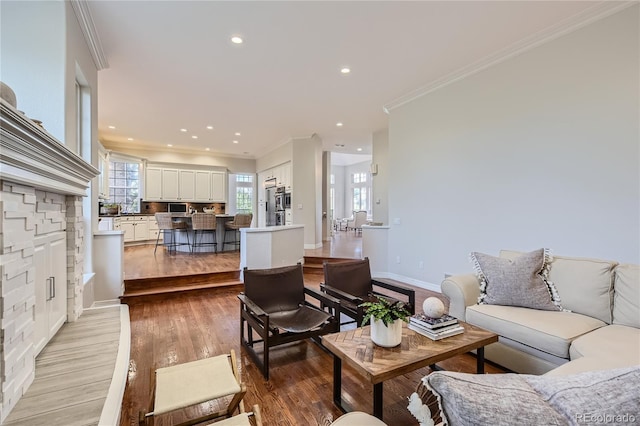 living room with a fireplace, light wood-type flooring, and ornamental molding