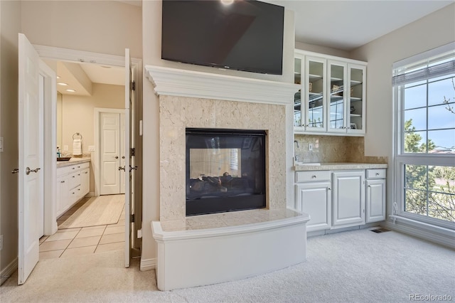 living room featuring a fireplace, light colored carpet, and sink