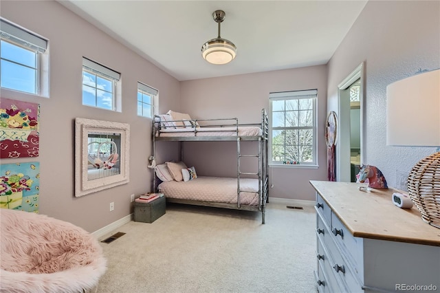 bedroom featuring multiple windows and light carpet