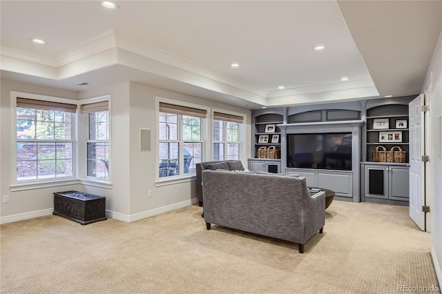 living room featuring light colored carpet, built in shelves, a raised ceiling, and crown molding