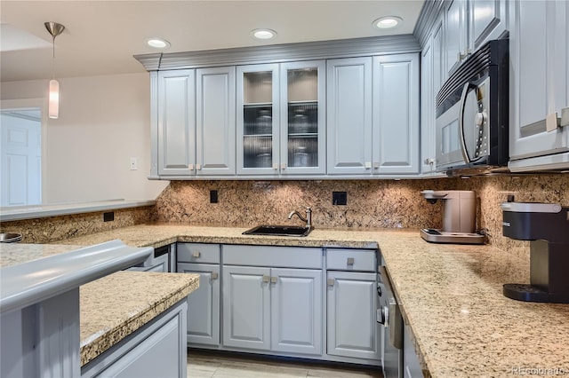 kitchen with gray cabinetry, sink, tasteful backsplash, and hanging light fixtures