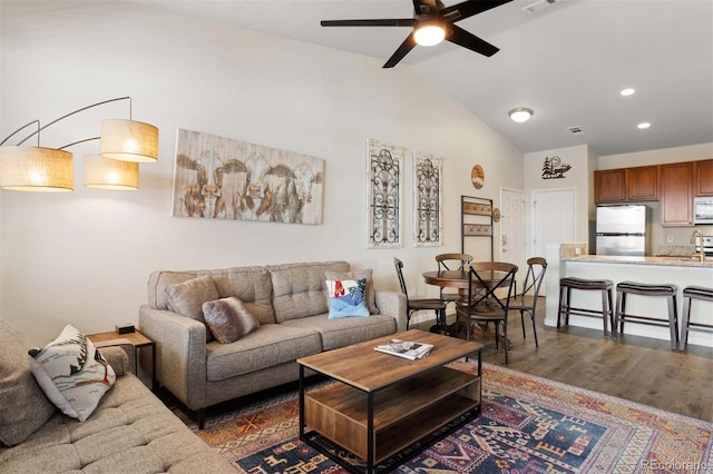 living room featuring ceiling fan, sink, lofted ceiling, and dark hardwood / wood-style floors