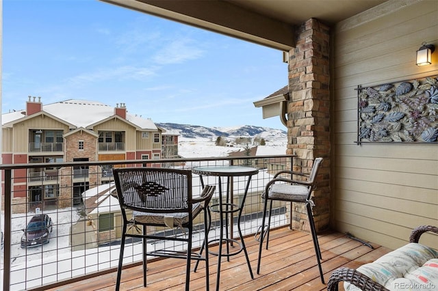 snow covered back of property with a mountain view