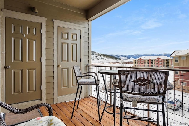 snow covered back of property featuring a mountain view