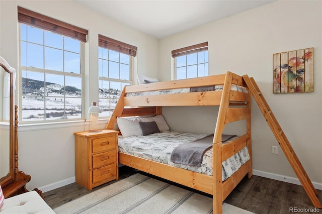 bedroom featuring multiple windows, a mountain view, and dark hardwood / wood-style floors