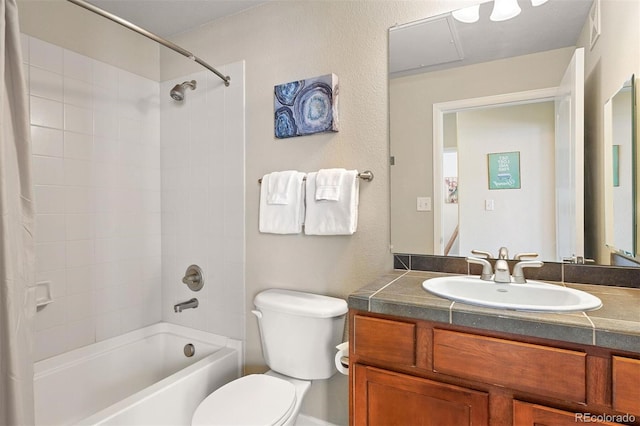 full bathroom featuring tiled shower / bath, vanity, and toilet