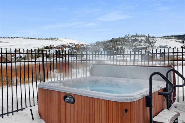 snow covered deck featuring a hot tub