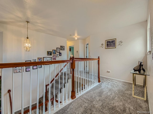 corridor featuring carpet floors and a notable chandelier