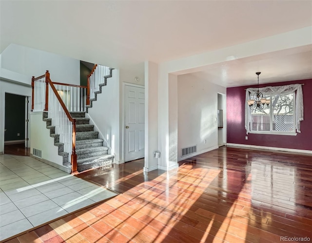 spare room with hardwood / wood-style floors and a notable chandelier